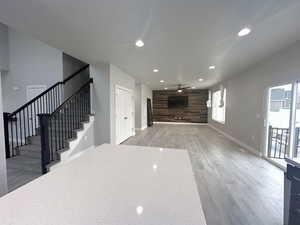 Unfurnished living room with ceiling fan and light wood-type flooring