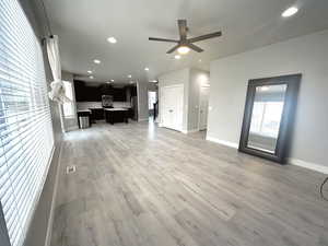 Unfurnished living room with sink, hardwood / wood-style flooring, and a wealth of natural light