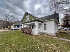 View of front of property with a front yard and covered porch