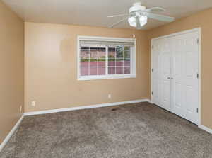 Unfurnished bedroom featuring ceiling fan, carpet floors, and a closet