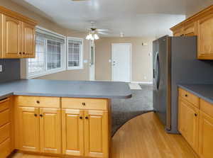 Kitchen with ceiling fan, light hardwood / wood-style floors, and stainless steel fridge with ice dispenser