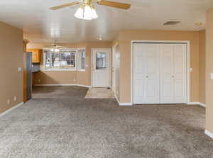 Interior space with light colored carpet and ceiling fan