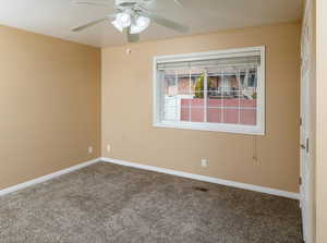 Empty room featuring carpet floors and ceiling fan