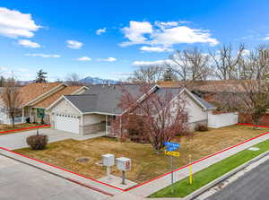 Ranch-style house with a garage, a mountain view, and a front lawn