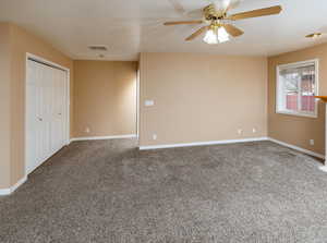 Carpeted empty room with ceiling fan