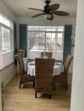 Dining room with ceiling fan and hard wood flooring.