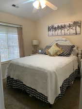 Bedroom featuring ceiling fan, carpet flooring, and vaulted ceiling