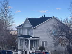 View of side of home, cherry trees, new roof.