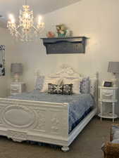 Bedroom featuring a notable chandelier and dark colored carpet