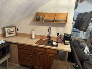 knotty alder cabinets, black sink with 8' butcher block. Laminate floors.