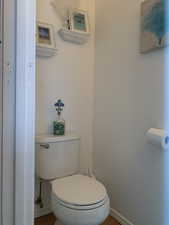 Bathroom with hardwood floors and toilet.