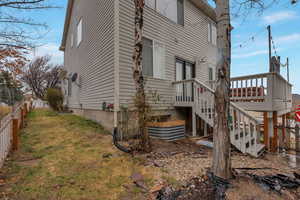 View of side of property featuring a lawn, deck.