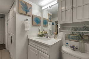 Bathroom featuring vanity, toilet, and tile patterned flooring