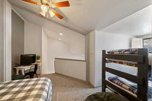 Carpeted bedroom featuring ceiling fan