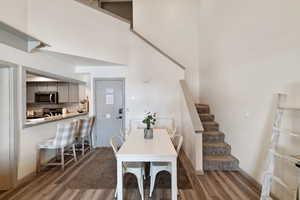 Dining room featuring a towering ceiling and dark wood-type flooring