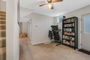 Workout room with light carpet and ceiling fan