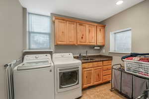 Laundry room featuring sink, cabinets, independent washer and dryer, and light tile patterned flooring