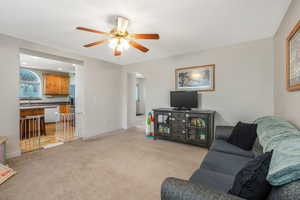 Carpeted living room with ceiling fan