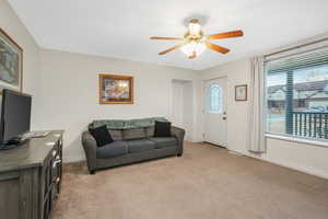 Living room with light carpet and ceiling fan