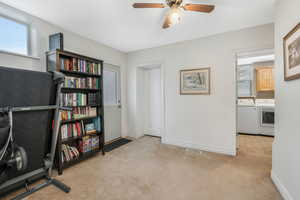 Carpeted office with ceiling fan and independent washer and dryer