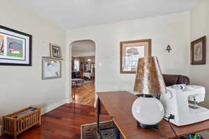 Office space with dark hardwood / wood-style flooring