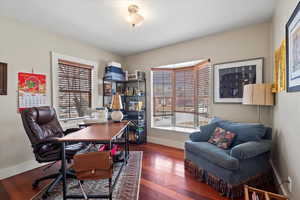 Home office featuring dark wood-type flooring