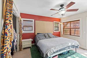 Carpeted bedroom featuring ceiling fan