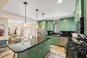 Kitchen with appliances with stainless steel finishes and green cabinets