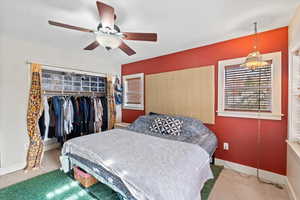 Bedroom with ceiling fan, carpet, and a closet