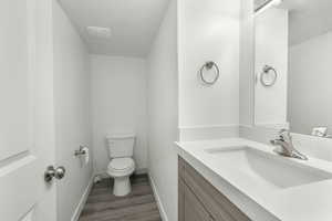 Bathroom featuring wood-type flooring, vanity, and toilet