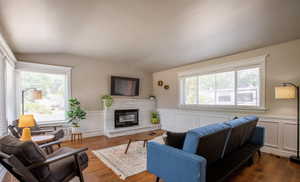 Living room with lofted ceiling, a fireplace, and a healthy amount of sunlight