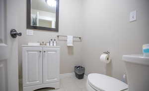 Bathroom featuring vanity, toilet, and tile patterned flooring