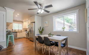 Dining space featuring dark wood-type flooring and ceiling fan