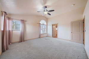 Main bedroom with connected bathroom, vaulted ceiling.