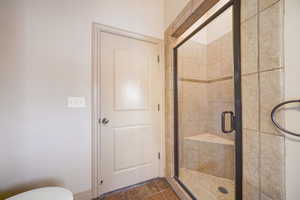 Bathroom also features a tiled shower with glass door