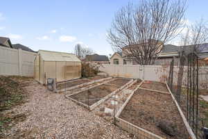 View of yard featuring greenhouse and built in garden beds!