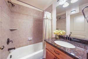 Main floor guest bathroom featuring vanity, shower / tub combo,