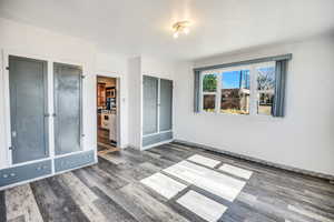 Unfurnished bedroom with dark hardwood / wood-style floors