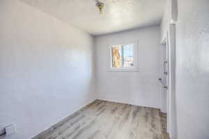 Unfurnished room featuring a textured ceiling and light hardwood / wood-style floors