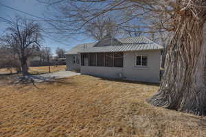 Back of house featuring a sunroom and a lawn