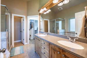 Bathroom with tile patterned floors, vanity, and a shower with shower door