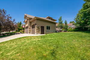 Back of property with a yard and a garage