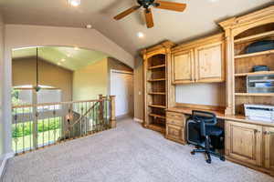 Office space with vaulted ceiling, light colored carpet, and ceiling fan