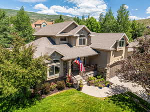 View of front of property with a garage, a mountain view, a porch, and a front yard