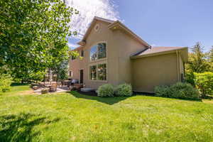 Rear view of property with a yard and a patio area