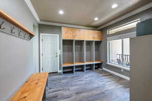 Mudroom with ornamental molding, dark hardwood / wood-style floors, and a textured ceiling