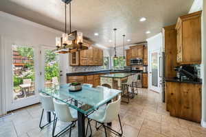 Dining area featuring ornamental molding and a textured ceiling