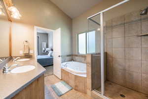 Bathroom featuring tile patterned flooring, vanity, vaulted ceiling, and independent shower and bath