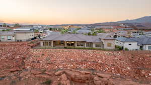 Back house at dusk featuring a mountain view