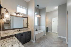 Bathroom featuring vanity, parquet flooring, separate shower and tub, and a high ceiling